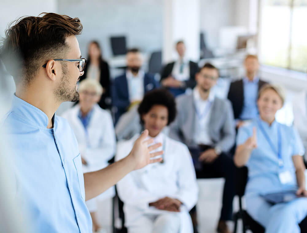 Mitarbeiter hält Präsentation vor Publikum aus medizinischem Personal und Fachleuten